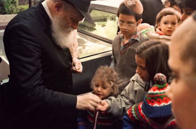 The Rebbe gives a young girl a coin so that she can donate it to charity (1980s). The Rebbe gives a young girl a coin so that she can donate it to charity (1980s).